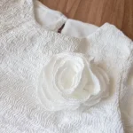 طرح گل‌دار روی پارچه کراپ شلوارک سفید کودکانه چیکوبای