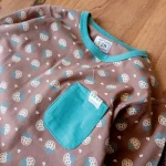 نمای نزدیک لباس راحتی دخترانه قهوه‌ای با چاپ توت‌فرنگی