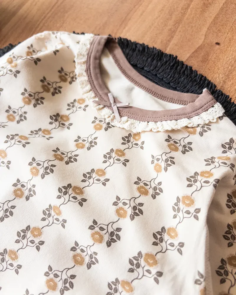 لباس راحتی کودک با پارچه پنبه‌ای کرم و یقه توری گل‌دار