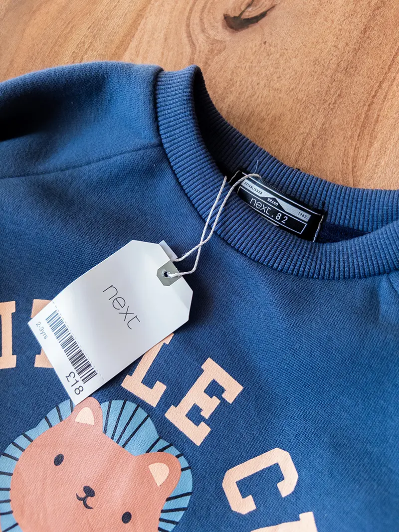 کلوزآپ گلدوزی شیر روی دورس سرمه‌ای نکست