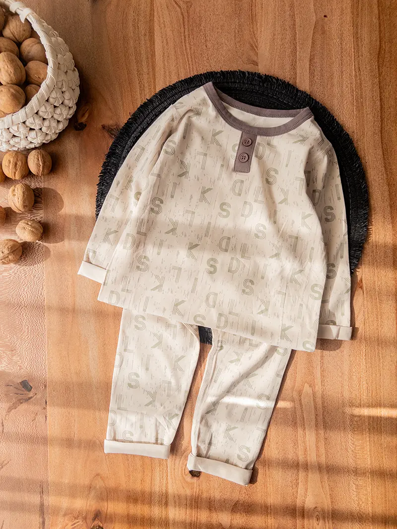 ست راحتی کودکانه کرم با یقه گرد و دو دکمه روی بلوز