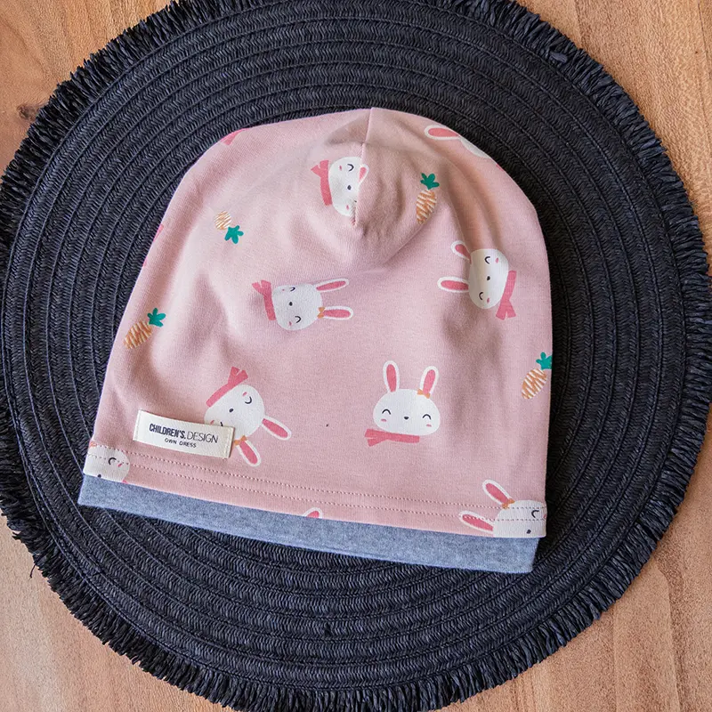 کلاه تدی دخترانه گوش‌دار صورتی با حاشیه طوسی