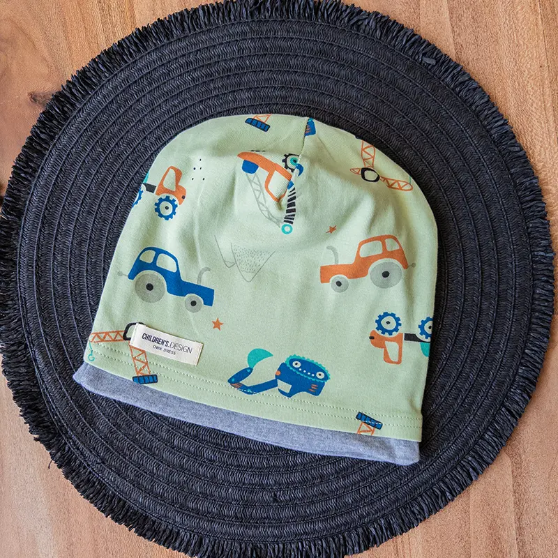 کلاه کودکانه با طرح کارتونی ماشین روی زمینه سبز