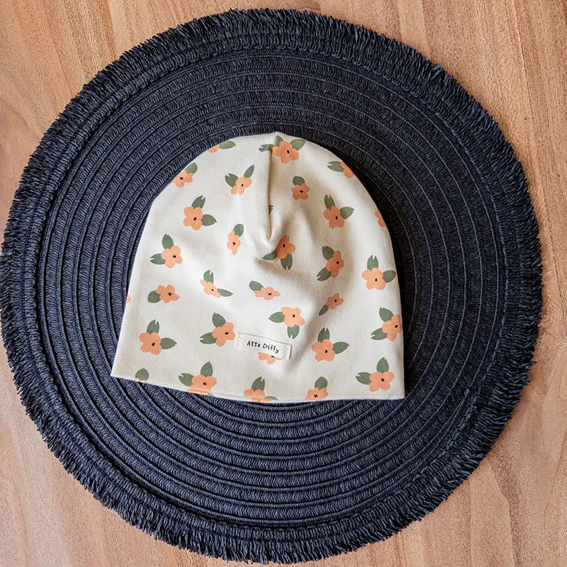 کلاه پنبه‌ای کودکانه نارنجی با طرح گل فانتزی